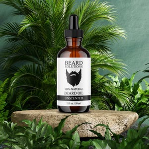 May include: A brown glass bottle of unscented beard oil with a black dropper. The label reads "BEARD SOLUTIONS" and "100% NATURAL BEARD OIL." The bottle is 2 fl. oz. / 59 ml. and is set on a stone with a green leafy background.