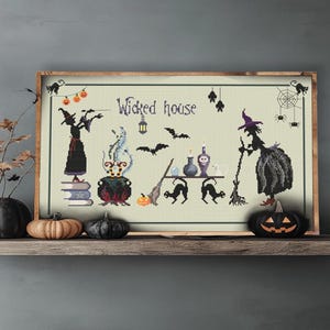 May include: A cross-stitch pattern featuring two witches, a cauldron, cats, and a sign that reads "Wicked House". The pattern is framed and displayed on a shelf with pumpkins.