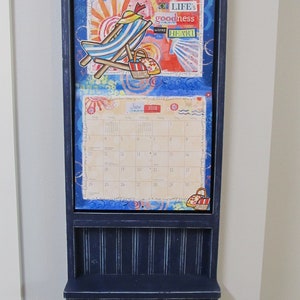 The Kim - Calendar Holder features a shelf and single larger hook. Built for seven popular calendar sizes. Price include shipping.