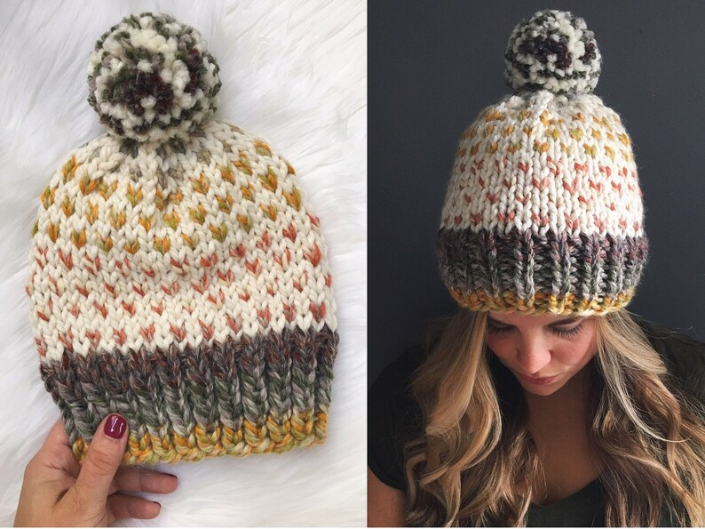 May include: A white knit beanie with a brown, white, and green pom pom. The beanie has a brown, white, and yellow stripe at the bottom.