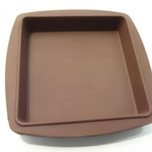 May include: A brown silicone baking pan with a square shape and rounded edges. The pan is designed for baking cakes, brownies, or other desserts.