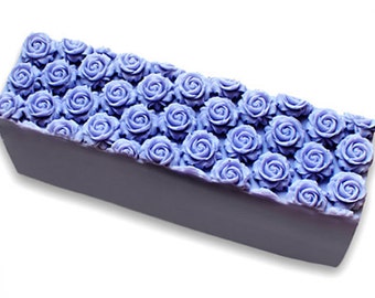 May include: A lavender-coloured bar of soap with a decorative design of purple roses on the top.