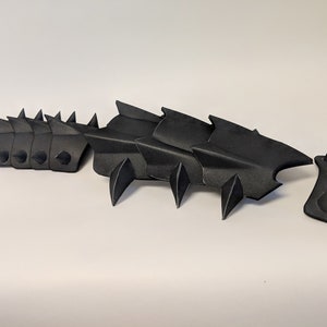 May include: Black plastic costume armor with spikes. The armor is made up of several pieces that can be connected together.