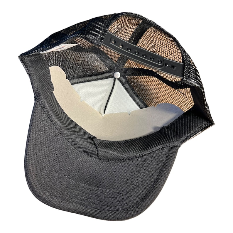 Op de afbeelding: Zwarte mesh truckercap met een zwarte klep en een witte mesh achterkant. De pet heeft een verstelbare plastic band.