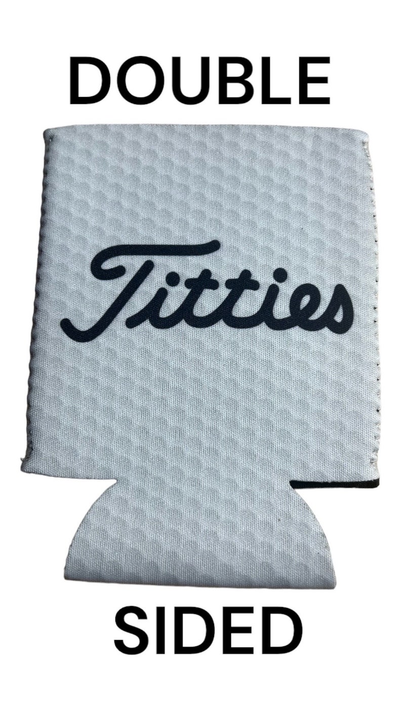May include: White double-sided can cooler with black text that says "Titties" and "DOUBLE SIDED".