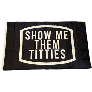 Puede incluir: Bandera negra con texto blanco "SHOW ME THEM TITTIES" dentro de un rectángulo con contorno blanco. La bandera tiene ojales en el lado izquierdo para colgar.