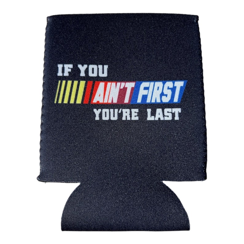 Pu&ograve; includere: Isolante per bevande nero con il testo bianco "IF YOU AIN'T FIRST YOU'RE LAST". Le parole "AIN'T FIRST" sono in un design colorato con strisce gialle, rosse e blu. L'isolante ha un fondo curvo per contenere una bevanda.
