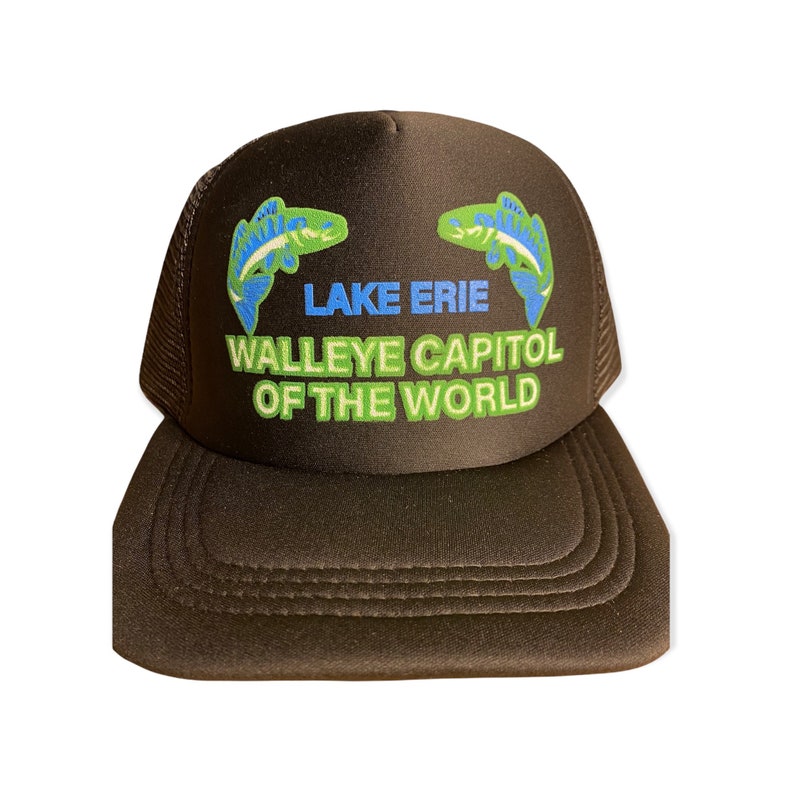 Op de afbeelding: Bruine truckerpet met een mesh achterkant en een gebogen klep. De voorkant toont de tekst "LAKE ERIE WALLEYE CAPITAL OF THE WORLD" in blauw en groen, met twee visillustraties.