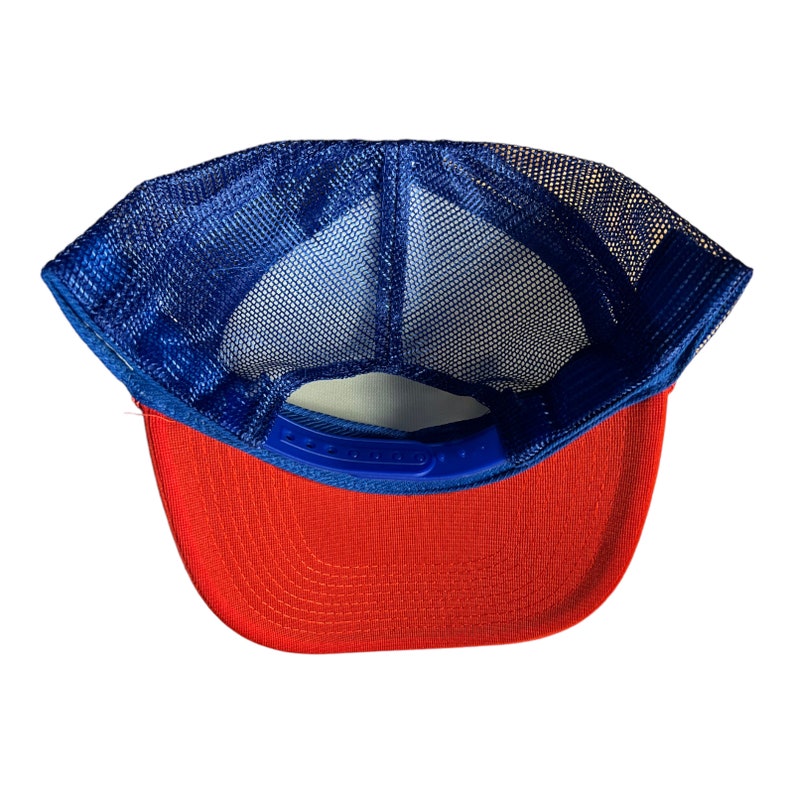 May include: A red and blue trucker hat with a mesh back. The hat is turned inside out, showing the blue mesh and the red fabric of the brim.