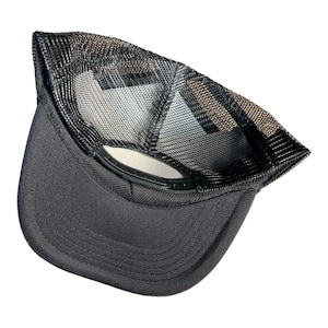 Op de afbeelding: Zwarte mesh truckercap met een zwarte klep en een zwarte verstelbare band. De pet is binnenstebuiten gekeerd om de mesh-rug te laten zien.