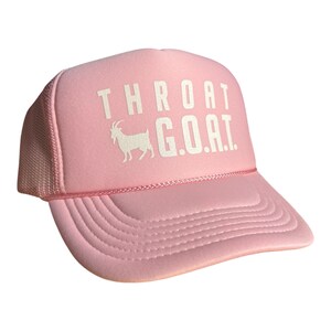 Pode incluir: Bon&eacute; de caminhoneiro rosa com uma silhueta de cabra branca e o texto "THROAT G.O.A.T."