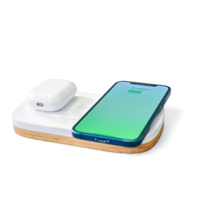 May include: A white wireless charging pad with a white wireless charging case for earbuds and a blue smartphone charging on the pad.