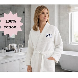 May include: A white waffle-weave cotton robe with a matching belt and pockets. The robe has the initials "RH" embroidered in navy blue on the chest. The image includes the text "100% cotton!"