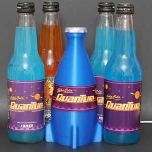 May include: Five glass bottles of blue and orange soda with a rocket-shaped bottle stopper. The bottles are labeled "Nuka Cola Quantum" with a purple background and a retro-futuristic design.