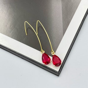 May include: A pair of gold earrings with red teardrop-shaped stones.