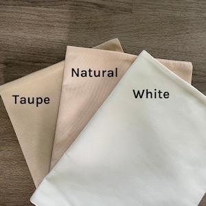 K&ouml;nnte beinhalten: Drei Stoffmuster in verschiedenen Beiget&ouml;nen. Die Muster sind mit "Taupe", "Natur" und "Wei&szlig;" beschriftet.