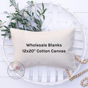 May include: A beige 12x20 inch cotton canvas pillow cover with the text "Wholesale Blanks 12x20" Cotton Canvas" printed in black.