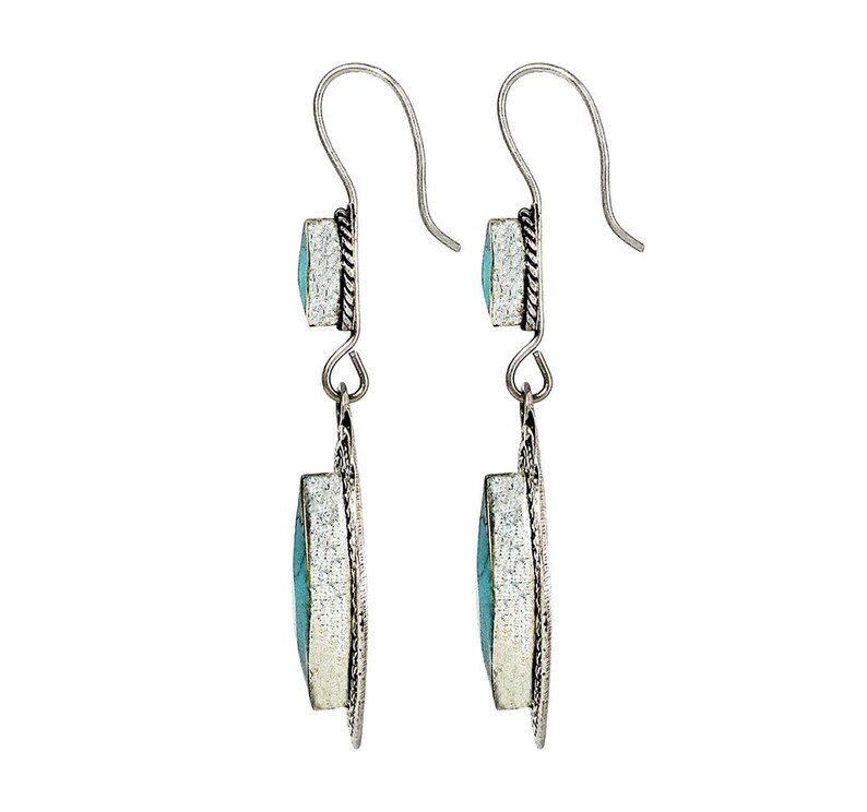 May include: A pair of silver dangle earrings with turquoise stones. The earrings have a simple design with a small turquoise stone at the top and a larger turquoise stone at the bottom.
