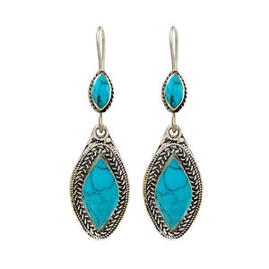 May include: A pair of silver dangle earrings with turquoise stones. The earrings have a teardrop shape and are decorated with intricate silver designs.