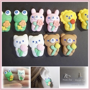 May include: A set of 10 colorful polymer clay earrings featuring various animal designs, including a frog, bunny, lion, cat, and bear. Each animal is holding a flower or a tulip. The earrings are available in both plastic clip and pierced post styles. "Juicebox Jewels" is written on the bottom of the image.