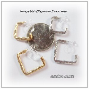 May include: Three pairs of invisible clip-on earrings. Two pairs are silver and one pair is gold. Each pair has a square shape with a twisted design. The earrings are shown next to a US dime for size comparison.