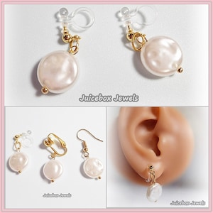 May include: A pair of gold-tone pearl earrings with a clip-on and a hook style. The pearls are white and round.