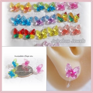 May include: Assortment of colorful butterfly clip-on earrings. The earrings are made of clear plastic with a butterfly design. The butterflies are in various colors, including red, yellow, blue, green, and pink. The earrings are shown on a white background. The text "Juicebox Jewels" is visible in the image.