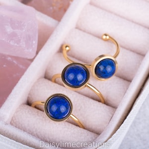 Peut inclure: Trois bagues en or avec des pierres précieuses bleues. Les bagues sont présentées dans un écrin à bagues en velours blanc.