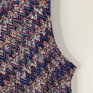 May include: A sleeveless dress with a geometric pattern in shades of blue, pink, white, and black.