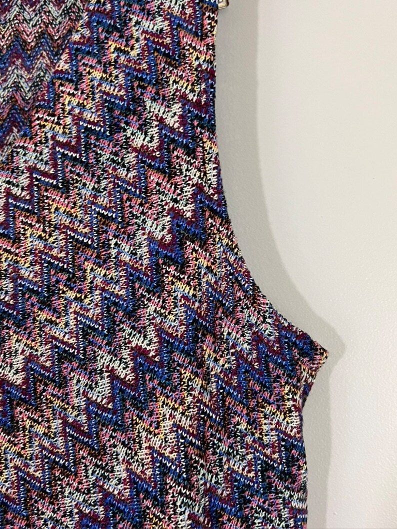 May include: A sleeveless dress with a geometric pattern in shades of blue, pink, white, and black.