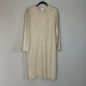 May include: A white and black houndstooth patterned dress with long sleeves. The dress has a round neckline and a zipper closure in the back.