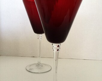May include: Two red wine glasses with a clear stem and base. The glasses have a textured rim and are made by the company "By Moravia Crystal".