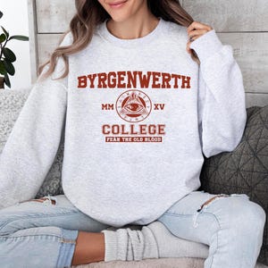 May include: Gray sweatshirt with a red print that says "Byrgenwerth College" with a stylized eye and the text "MM XV Fear the Old Blood".