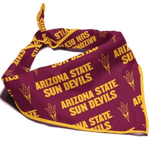 Op de afbeelding: Een maroon bandana met een gele rand en een herhalend patroon van de woorden "Arizona State Sun Devils" en een gestileerde zon met een speerontwerp.