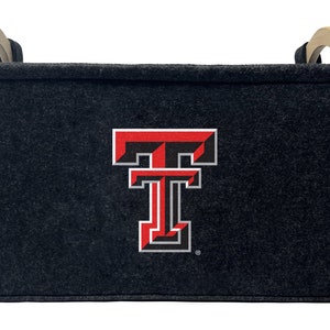 May include: A black felt storage bin with wooden handles and a red and black Texas Tech University logo.