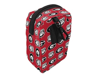 May include: A red zippered pouch with a black zipper and a repeating pattern of white bulldog heads and the letter "G" in a circle.