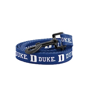 May include: A blue dog leash with a black metal clip. The leash has the word "DUKE" and the Duke University logo printed on it in white.