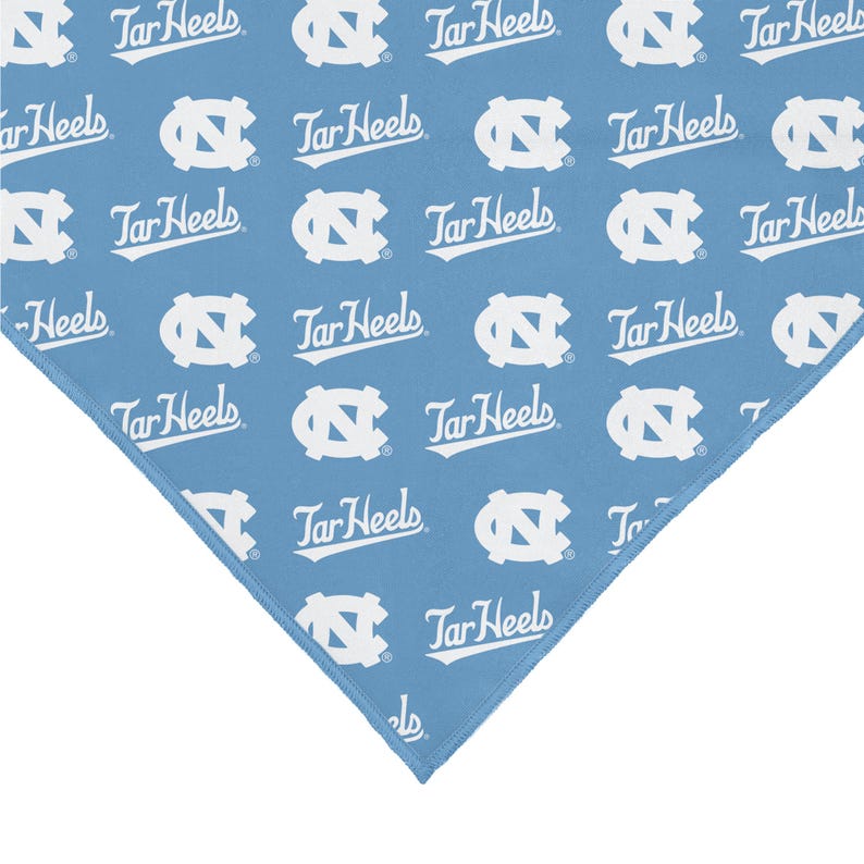 May include: A blue bandana with a white repeated pattern of the University of North Carolina Tar Heels logo and the words "Tar Heels".