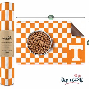 May include: Orange and white checkered pet feeding mat with a large white "T" in the lower right corner. The mat is 18 inches by 29 inches and has a non-slip, waterproof backing.