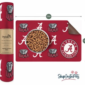 May include: Red and white Alabama Crimson Tide pet feeding mat with a non-slip, waterproof surface. The mat features a repeated pattern of the Alabama 'A' logo, an elephant, and the word 'BAMA'. The mat measures 18 inches by 29 inches.