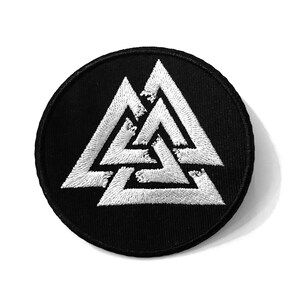 May include: A black embroidered patch featuring a white Valknut symbol, a Norse symbol representing the connection between the realms of the gods, the living, and the dead.