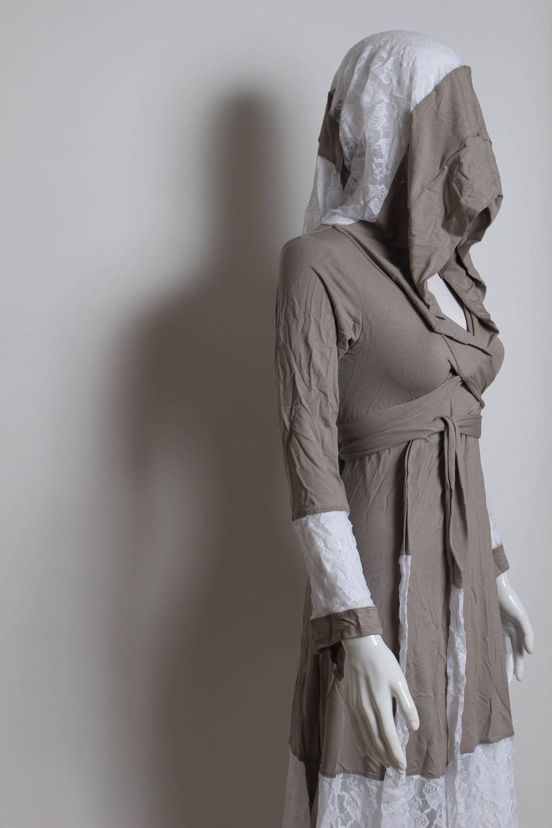 May include: A long-sleeved, brown dress with a white lace trim. The dress has a hood and a tie at the waist.