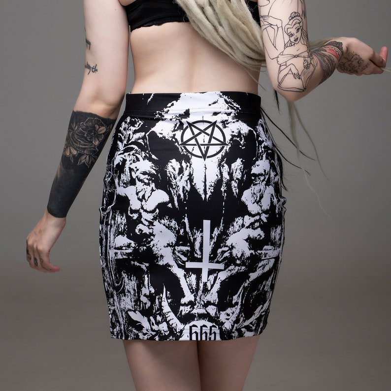 May include: Black and white mini skirt with a graphic print of a skull, pentagram, and cross. The skirt has the number 666 printed on the bottom.