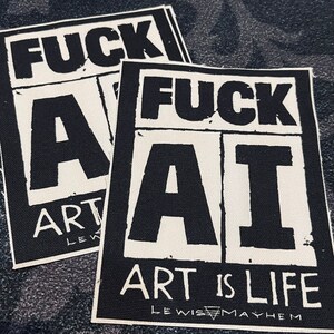 May include: Two white fabric patches with black text. The top patch says "FUCK ART" and the bottom patch says "FUCK AI ART IS LIFE LEWIS MAYHEM".