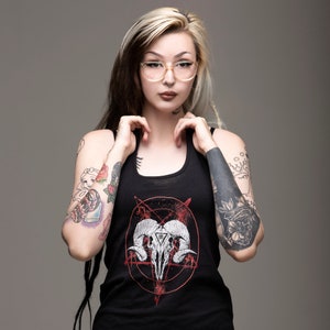 May include: A black tank top with a red pentagram and a white skull with horns graphic. The model is wearing the tank top and has long blonde hair with black dreadlocks.