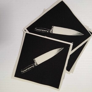 May include: Three black fabric patches with a white outline of a kitchen knife on each.
