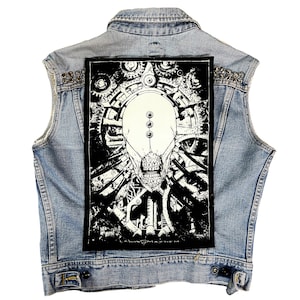 May include: Black and white back patch featuring a skull-like face surrounded by gears and machinery. The text "Leviathan" is visible at the bottom of the patch.