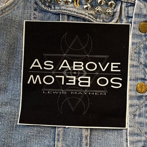 May include: Black and white patch with the text "As Above So Below" and "Lewis Mayhem" on a denim jacket.