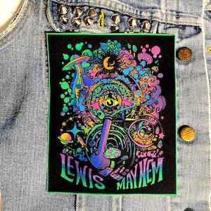 Peut inclure: Un patch thermocollant noir avec une bordure verte. Le patch présente un motif psychédélique avec un grand œil, une pipe et le texte "Lewis Mayhem".