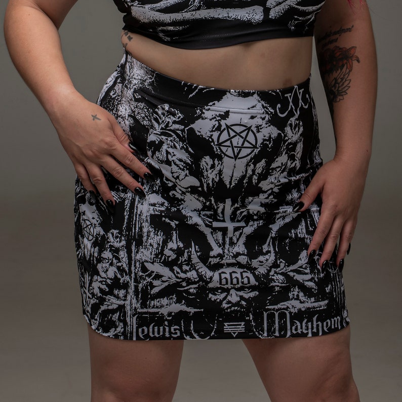 May include: Black and white mini skirt with a graphic print of a pentagram, a cross, and the number 666. The text "Lewis" and "Mayhem" are also printed on the skirt.